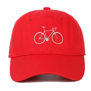 Close-up of white bicycle embroidery on a red cotton baseball cap with curved visor