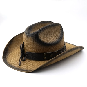 Close-up of cowboy straw hat with faux leather band and metallic bull head emblem