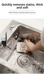 Detailed view of thick duck-patterned wood pulp sponge cleaning a stainless steel sink