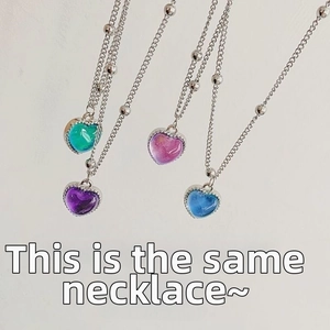 Detail showing heart necklace color changes from blue to pink on silver beaded chain