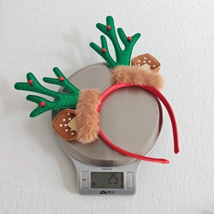 Weight measurement showing Christmas reindeer antler headband weighs 25.1 grams