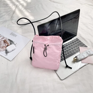Borsa a tracolla in nylon rosa con coulisse su lenzuola con accessori tech
