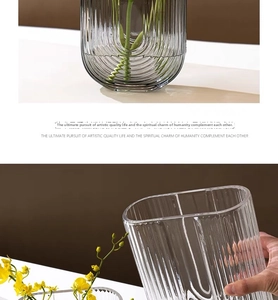 Detail of grey ribbed glass vase showing vertical texture and rounded polished rim