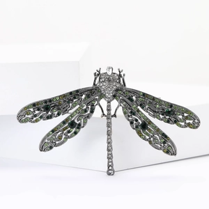 Detailed close-up of a vintage dragonfly brooch with green and white rhinestones