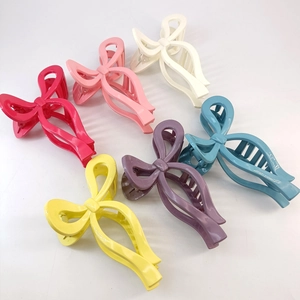 Detail of six colorful glossy bow-shaped hair claws in various vibrant macaron shades
