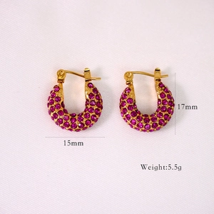 Detailed macro view of 15mm gold hoop earrings with inlaid rose red cubic zirconia