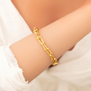 Close-up of a 18k gold plated titanium steel U-link chain bracelet on a woman's wrist