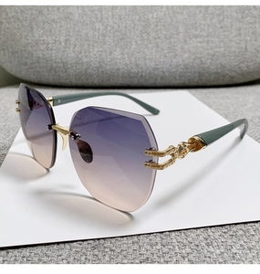 Detalle de lentes degradadas sin montura con varillas grabadas doradas y puntas verdes