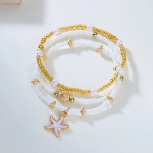 Detail of bohemian layered necklace set featuring white seed beads, starfish and shell charms