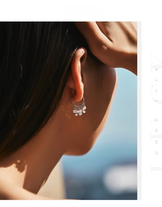 Detail of s925 silver beaded hoop earrings with shimmering zircons on model