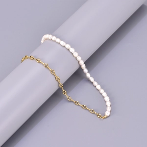 Detail of half pearl and gold chain necklace wrapped on a cylinder prop