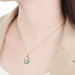 Gros plan d'un collier pendentif sapin de Noël avec finition émail vert et rouge vif