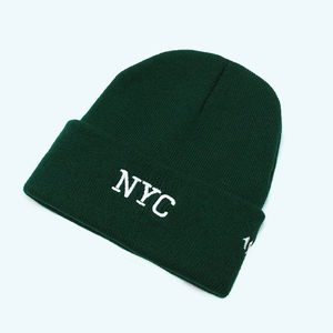 Detailed close-up of NYC white embroidery on forest green ribbed knit beanie cap