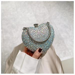 Macro shot of shimmering iridescent rhinestones on heart-shaped evening clutch bag