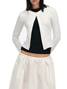 Detail of white knit cardigan with buttons and matching pleated skirt on a model
