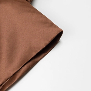 Close-up of brown satin fabric texture and fine stitching on elegant puff sleeves blouse