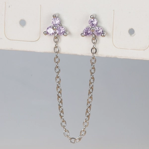 Macro shot of silver chain earrings with three purple zircon flower studs on display