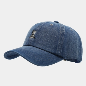 Detailed close-up of cat embroidery on washed denim baseball cap with premium stitching