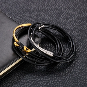 Detail view of double-wrapped black leather bracelet with gold and silver fishhook clasp