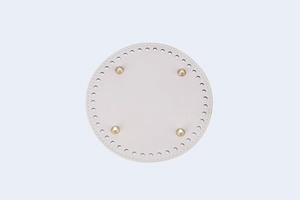 Detail of 15cm round PU leather bag bottom base with gold rivets and pre-drilled holes