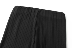 Detalle de la cintura alta de punto acanalado negro y textura de tela de los pantalones