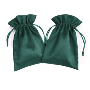 Dark green velvet drawstring jewelry pouches for gift packaging and storage on white background