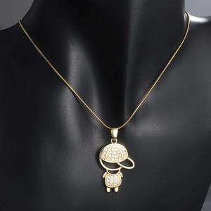 Detailed close-up of a gold-plated necklace with a zircon-studded boy pendant on a black bust