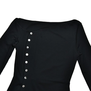 Detail view of the irregular neckline and silver buttons on this black slit dress