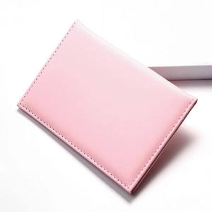 Close-up of pink PU leather passport holder showing fine stitching and minimalist texture