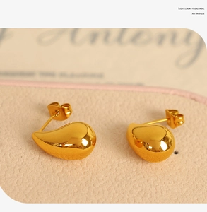 Macro shot of 18K gold plated teardrop earrings with a polished surface in a jewelry box