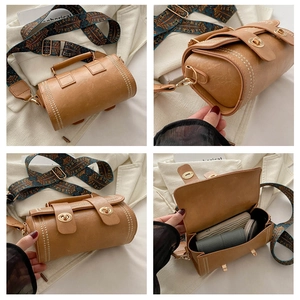 Macro view of retro cylinder Boston bag with embroidered wide strap and PU leather texture