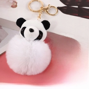 Detail view of panda plush keychain with soft faux fur pompom and golden metal clasp
