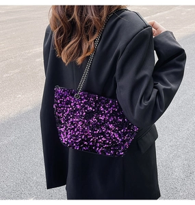 Chic purple sequin chain bag styled with a black blazer in an outdoor street setting