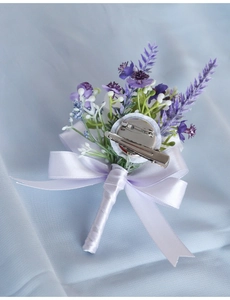 Detail view of purple artificial boutonniere showing secure pin and clip attachment