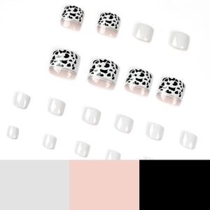 Press-on toenails set featuring chic black and white cow patterns and solid white finish