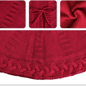 Red knit Christmas tree skirt with cable stitch patterns and a decorative bow tie
