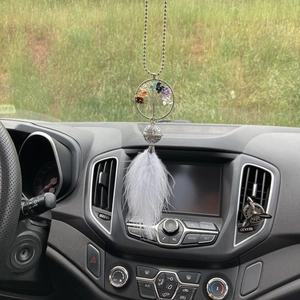 Detail of life tree car charm featuring colorful crystal chips and white feathers