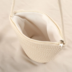 Detail view of woven cotton shell bag interior showing white lining and metal zipper