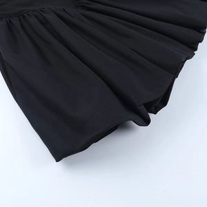 Gros plan du tissu plissé noir et des coutures texturées de cette robe courte bouffante