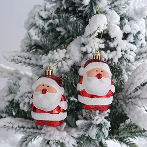 Par de colgantes de Papá Noel con purpurina roja y blanca en un árbol de Navidad nevado