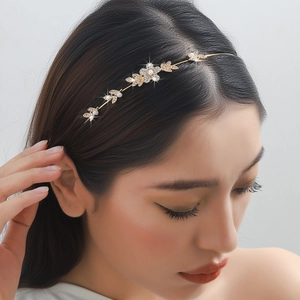 Serre-tête doré à fleurs et feuilles avec perles et strass porté par un mannequin