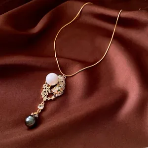 Golden leopard head necklace with zircon, green stone eyes and twin pearls on silk
