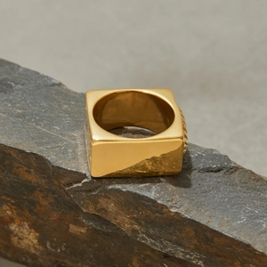 Gros plan d'une bague chevalière carrée en or 18 carats avec texture striée verticale