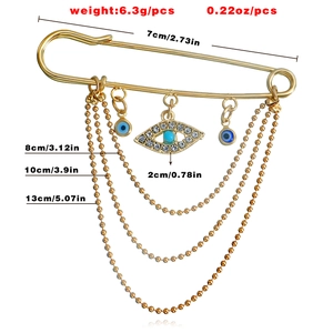 Gold evil eye safety pin brooch with sparkling rhinestone charms and layered chains