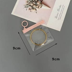 Detailed view of a 9x9cm clear EVA jewelry storage pouch with pink zipper for bracelets
