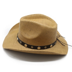 Dettaglio di un cappello da cowboy in paglia intrecciata con fascia in pelle borchiata