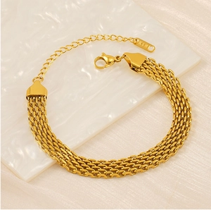 Detail of gold woven mesh bracelet with adjustable lobster clasp on silk background