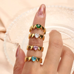 Close-up of four stacked 18K gold-plated heart-shaped zircon rings in multiple colors