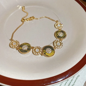 Nahaufnahme des 18K vergoldeten Armbands mit Zirkonia und Tigerauge-Muscheleinlagen