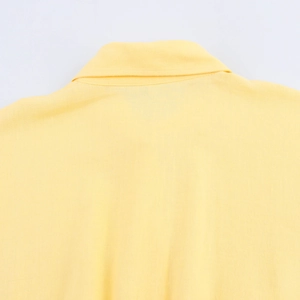Detailed close-up of the yellow shirt collar and stitching on premium soft fabric